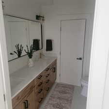 Full bathroom with double vanity and light tile patterned floors