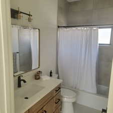 Full bathroom featuring shower / tub combo with curtain, vanity, and light tile patterned floors