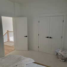 Carpeted bedroom with a closet and baseboards