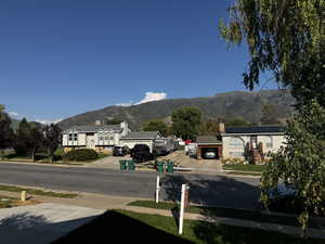 View of asphalt road featuring sidewalks and a mountain view