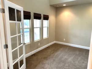 Carpeted spare room featuring recessed lighting and french doors
