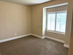 Empty room featuring baseboards and carpet flooring