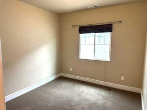 Empty room featuring carpet flooring and baseboards