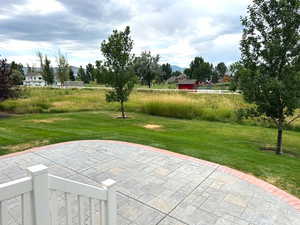 View of property's community featuring a lawn and a patio area