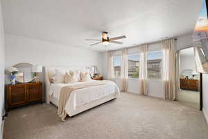 Bedroom featuring carpet floors, arched walkways, ceiling fan, and a textured ceiling