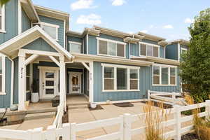 View of front of property featuring board and batten siding, a fenced front yard, and a gate