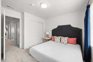 Bedroom featuring carpet and a closet