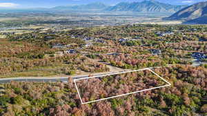 Aerial overview of property's location with property boundaries highlighted and a mountainous background