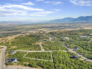 Aerial view of property's location featuring a mountainous background and property parcel outlined