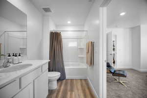 Full bathroom featuring shower / bath combination with curtain, vanity, dark wood finished floors, and recessed lighting
