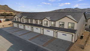 View of front facade featuring a mountain view, stucco siding, and concrete driveway
