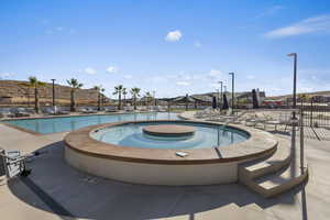 Community pool with a patio area and a hot tub
