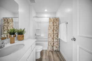 Bathroom featuring shower / bath combination with curtain, vanity, and light wood-type flooring