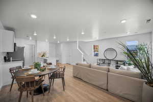 Dining space featuring light wood-style flooring, stairway, and recessed lighting