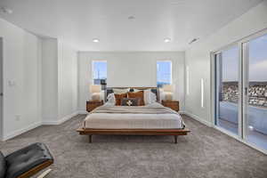 Carpeted bedroom featuring baseboards and access to exterior
