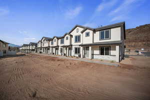 View of front facade with stucco siding and covered porch
