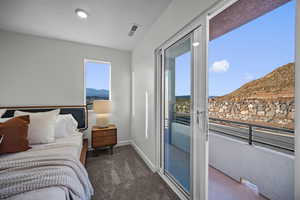 Bedroom featuring a mountain view, dark carpet, and access to exterior