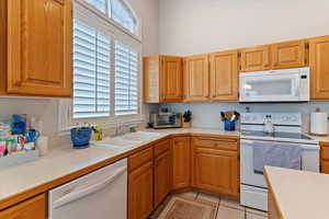 Kitchen with light countertops, white appliances, and light tile patterned floors