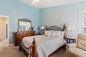 Carpeted bedroom with ceiling fan and baseboards