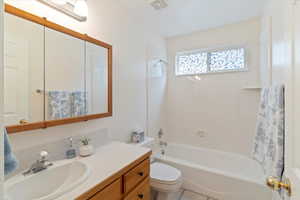 Bathroom with bathing tub / shower combination, vanity, and light tile patterned floors