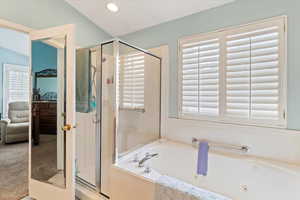 Bathroom with ensuite bath, a shower stall, and a whirlpool tub