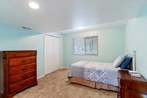 Bedroom with carpet floors, a closet, and a textured ceiling