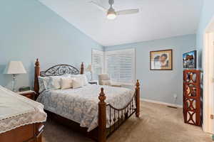 Bedroom with carpet floors, vaulted ceiling, and ceiling fan