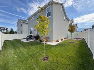 Back of house with a fenced backyard, a patio area, and stucco siding