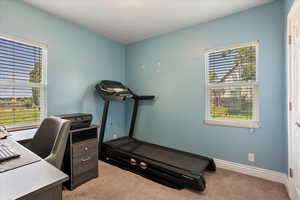 Office area featuring light carpet and baseboards
