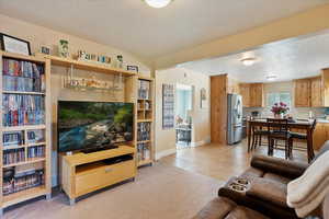 Living area featuring light colored carpet, light tile patterned flooring, and a textured ceiling