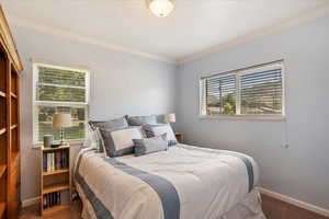 Bedroom with ornamental molding and carpet flooring
