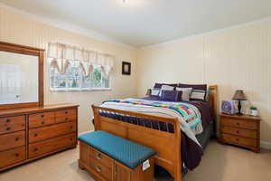 Bedroom with light colored carpet and crown molding