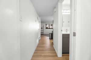 Hallway with light wood-style flooring and baseboards