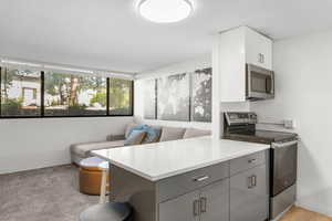 Kitchen featuring stainless steel appliances, a peninsula, open floor plan, a textured ceiling, and a breakfast bar