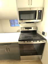 Kitchen with appliances with stainless steel finishes and light countertops