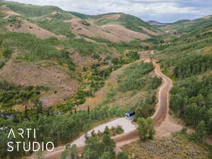 Aerial view of property and surrounding area featuring a mountain backdrop