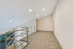 Spiral staircase that leads to a loft above primary bedroom