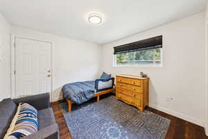 Bedroom featuring dark wood-type flooring and baseboards
