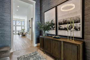 Hall with a chandelier, recessed lighting, a towering ceiling, and parquet flooring