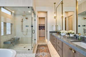 Full bath featuring a shower stall, a walk in closet, double vanity, and a freestanding bath