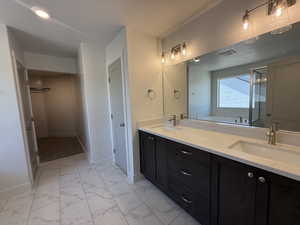 Full bathroom featuring double vanity, a garden tub, light marble finish floors, a stall shower, and a walk in closet
