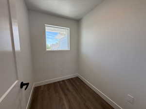 Spare room featuring dark wood finished floors and a textured ceiling
