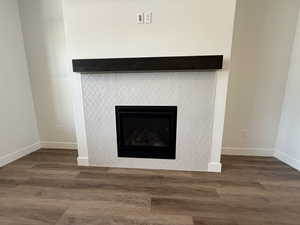 Detailed view of wood finished floors and a tile fireplace