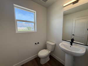Half bath featuring baseboards and dark wood-style flooring
