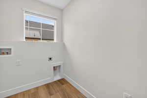 Laundry area featuring wood finished floors, electric dryer hookup, and washer hookup