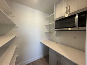 Unfurnished office featuring dark wood-type flooring and baseboards