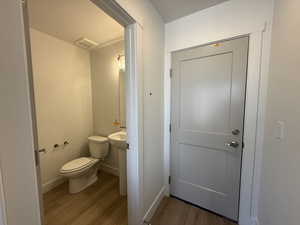 Half bathroom with light wood-type flooring and baseboards