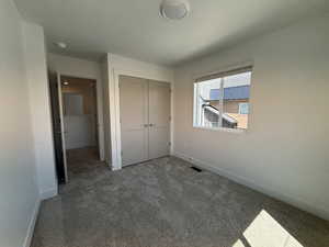 Unfurnished bedroom with carpet and a closet