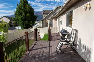 Deck featuring a fenced backyard, area for grilling, a mountain view, and a residential view