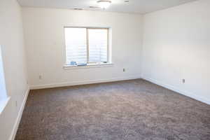 Carpeted empty room featuring baseboards